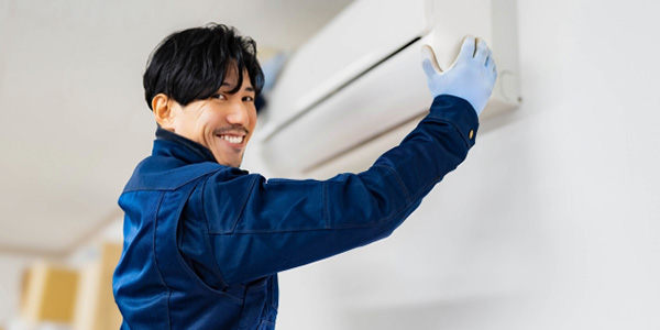 エアコンを取り外す作業員