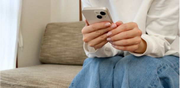 スマートフォンで申し込む女性